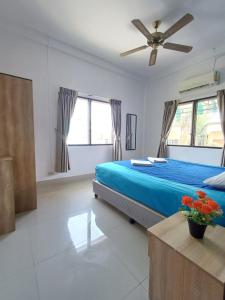 um quarto com uma cama azul e uma ventoinha de tecto em The Villa Residences Resort em Praia de Patong