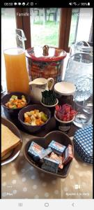 una mesa con tazones de comida y un vaso de zumo de naranja en La croix des Landes gîte ou chambre d'hôte avec piscine à Chouvigny, en Chouvigny