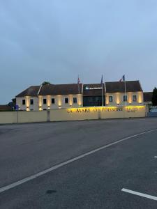 a bus is parked in front of a building at Hotel Best Western La Mare Ô Poissons in Ouistreham