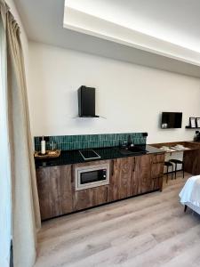 a kitchen with wooden cabinets and a tv on the wall at RentAdore Retiro Studio in Madrid