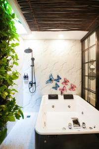 a bathroom with a white tub and a shower at Oak Tree Urban in Jakarta