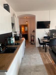 - une cuisine avec des placards blancs et une table dans une pièce dans l'établissement Apartament w centrum przy Studni 2, à Chełm