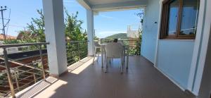 a balcony of a house with a table and chairs at Jon rooms in Himare