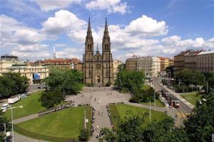 una grande cattedrale con una torre dell'orologio in una città di Cosy warm apartment in the heart of Prague. a Praga