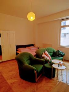 a living room with two chairs and a bed at Cosy warm apartment in the heart of Prague. in Prague