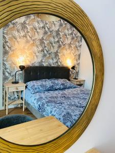 a bedroom with a bed with a large round mirror at Apartament przy plaży Willa Redłowo in Gdynia