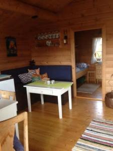 una sala de estar con una mesa blanca en una cabaña en Mountain cabin Skoldungbu, en Vang I Valdres