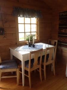 - une table et des chaises dans une chambre avec fenêtre dans l'établissement Mountain cabin Skoldungbu, à Vang I Valdres