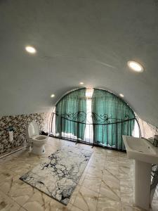 een badkamer met een toilet, een wastafel en een raam bij Отель РАЗАМ in Bosteri