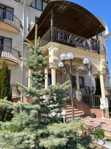 a house with a tree in front of it at RAZAM Hotel Bosteri in Bosteri