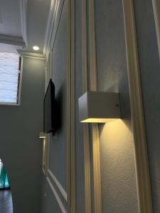 una luce è attaccata a un muro in una stanza di Отель РАЗАМ a Bosteri