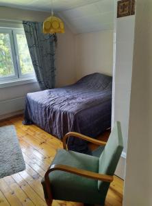 a bedroom with a bed and a chair and a window at Vintage 50's in Lahti