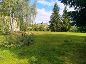 a field of grass with trees and a building at Vintage 50's in Lahti