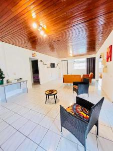 una sala de estar con muebles y techo de madera. en Chez Aniaki en Nuku Hiva