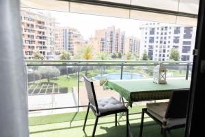 einen Balkon mit einem Tisch und Stühlen sowie Aussicht in der Unterkunft Modern apartment, Pool & Air con, San Juan Playa in Alicante