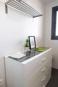 eine weiße Küche mit einer Theke mit einer Pflanze darauf in der Unterkunft Modern apartment, Pool & Air con, San Juan Playa in Alicante