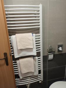 a towel rack in a bathroom with white towels at Hotel Dakol in Petrovice u Karviné