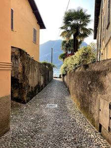 a stone alley with a palm tree and a building at Casa Victoria - Bellagio in Bellagio