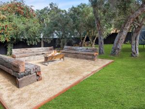 two wooden benches in a park with a dog sitting on a table at Bella Rye by Ready Set Stay - BYO LINEN & TOWELS in Rye