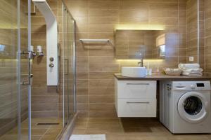 a bathroom with a washing machine and a shower at Modular Bungalows With Heated Pool Artemis Greece in Artemida