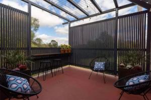 a patio with chairs and tables and a glass roof at The Old Chocolate Shop in Canowindra