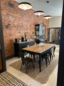 a table and chairs in a room with a brick wall at The Old Chocolate Shop in Canowindra