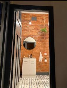 a bathroom with a sink and a brick wall at The Old Chocolate Shop in Canowindra