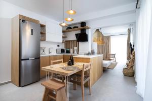 a kitchen with a table and a refrigerator at RASTONI VILLAS BY AEGEAN HOUSES in Psalidi