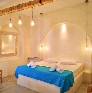 a bedroom with a bed with a blue table at Mistral-Patmos in Patmos