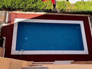 une piscine bleue à côté d'un bâtiment dans l'établissement ADOME Apartment Nautico IV, à Santa Pola