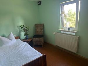 ein Schlafzimmer mit einem Bett, einem Fenster und einem Stuhl in der Unterkunft Monteurshaus im Leipziger Süde nähe A38 in Leipzig