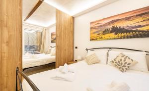 une chambre avec un lit blanc et un miroir dans l'établissement Da Laura a Ponte Vecchio, à Florence