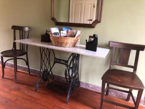 a table with a basket on it with two chairs at Casa de Campo Pumarada de Oirín in Foz