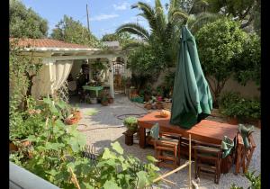 Ambelákia的住宿－Αρμονία，一个带桌子和遮阳伞的庭院
