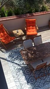 a patio with an orange couch and a table and chairs at Semiramis Urla Guesthouse in Urla