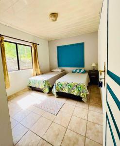 sypialnia z 2 łóżkami i oknem w obiekcie Chez Aniaki w Nuku Hiva