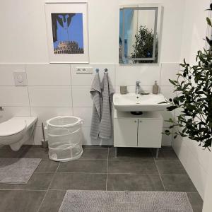 Luxuriöses Apartment,Neubau, 4 Personen, Parkplatz, Griechischer Stil في بوخوم: حمام أبيض مع حوض ومرحاض