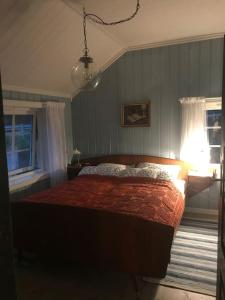 a bedroom with a bed with a red bedspread and a lamp at The Olav-house from 1840, at farm Ellingbø in Vang I Valdres