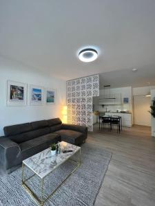 Luxuriöses Apartment,Neubau, 4 Personen, Parkplatz, Griechischer Stil في بوخوم: غرفة معيشة مع أريكة وطاولة
