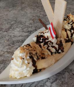a banana split on a plate on a table at Zimmer und Appartement Marktcafe Sankt Peter am Kammersberg 87 in Sankt Peter am Kammersberg