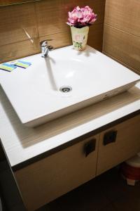 a bathroom sink with a vase of flowers on it at Pensiunea Oxana in Lipova