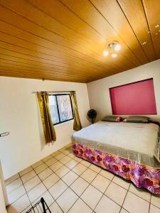a bedroom with a bed and a wooden ceiling at Chez Aniaki in Nuku Hiva