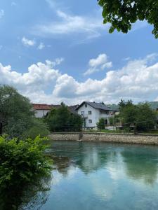 une masse d’eau avec des maisons et des bâtiments en arrière-plan dans l'établissement River Heaven Eda, à Bosanska Krupa
