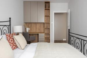 ein Schlafzimmer mit einem Bett und einem Schreibtisch in der Unterkunft Metro Kabaty Elegant Apartment by BookingHost in Warschau