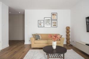 ein Wohnzimmer mit Sofa und Tisch in der Unterkunft Metro Kabaty Elegant Apartment by BookingHost in Warschau