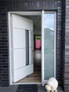 eine offene Tür eines Hauses mit einem Teddybären draußen in der Unterkunft Idylisches Ferienhaus in Edewecht