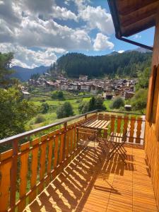 a wooden balcony with a view of a town at Un balcone sulla Val di Pejo in Peio