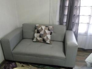 um sofá num quarto com uma almofada em Erima Lodge em Joanesburgo
