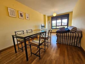 - un salon avec une table, des chaises et un canapé dans l'établissement 1A106 Amplio y cómodo apartamento, à Gijón
