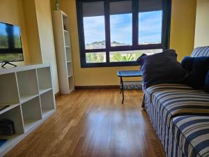 sala de estar con sofá y ventana grande en 1A106 Amplio y cómodo apartamento, en Gijón